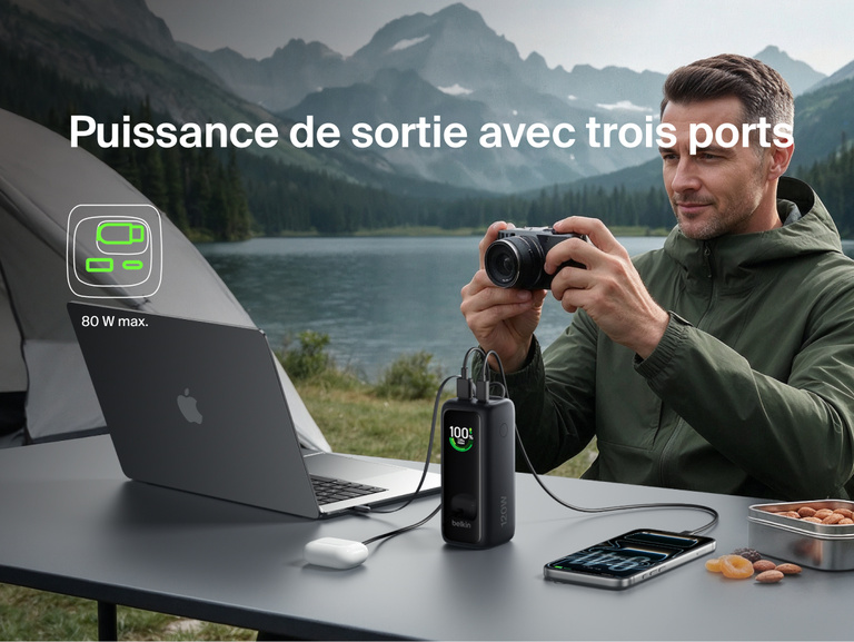 Image d'une batterie externe 22K UltraCharge avec c&acirc;ble r&eacute;tractable rechargeant simultan&eacute;ment un ordinateur portable, un appareil photo et un t&eacute;l&eacute;phone lors d'une sortie camping, avec une puissance de sortie maximale de 80&nbsp;W sur trois&nbsp;ports.