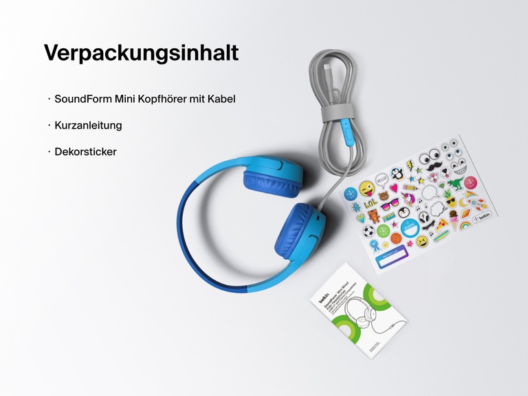 Flat lay image showing the contents of the Belkin SoundForm Mini Wired Headphones box, including the headphones, a quick start guide, and a sheet of decorative stickers.