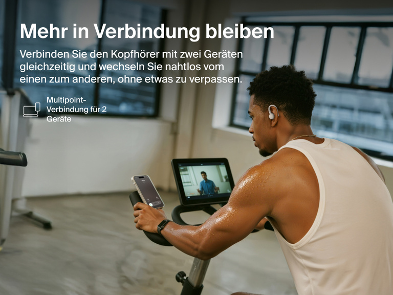 Belkin SoundForm ActiveFit Wireless Earbuds with multipoint 2-device connection, shown on a man using them while cycling on a stationary bike.