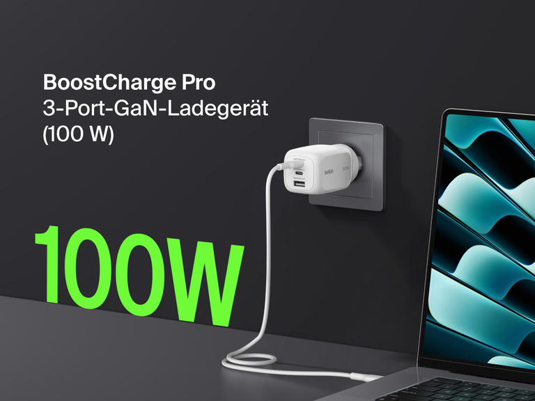BoostCharge Pro 3-Port GaN Wall Charger 100W plugged into a wall outlet, fast charging a laptop with bold green “100W” text highlighting its powerful output.