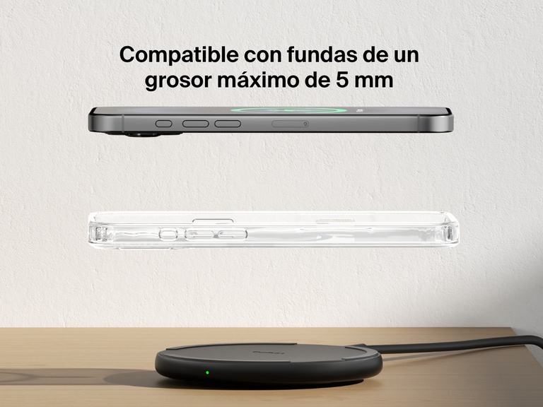 A black Belkin BoostCharge Wireless Charging Pad 15W is shown on a wooden surface with an iPhone and a transparent case floating above it, highlighting its compatibility with cases up to 5mm thick.