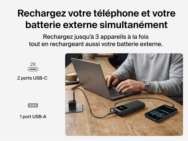 Image d'une batterie externe 11K UltraCharge avec c&acirc;ble r&eacute;tractable rechargeant simultan&eacute;ment un ordinateur portable et un t&eacute;l&eacute;phone sur un bureau via son c&acirc;ble r&eacute;tractable, ses ports USB-C et son port USB-A.