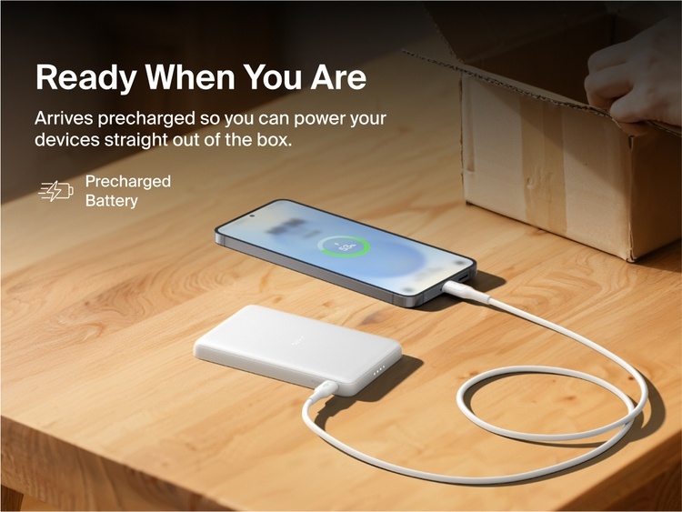 Belkin BoostCharge Slim Magnetic Power Bank 5K shown charging a smartphone on a table, highlighting its precharged battery ready for instant use out of the box.