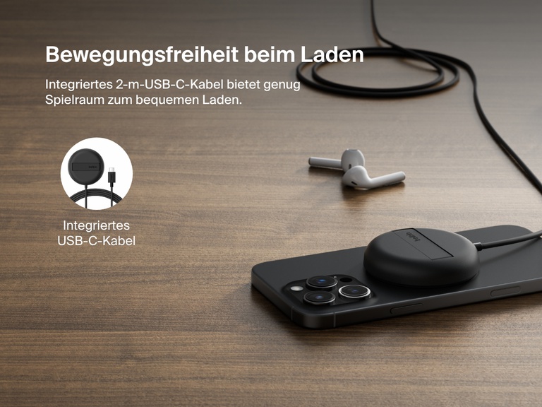 Ein schwarzes, magnetisches, kabelloses Belkin BoostCharge Pro-Ladegerät mit Qi2 und15 Watt wird gezeigt, wie es ein iPhone auf einer Holzoberfläche mit einem integrierten 2-m-USB-C-Kabel für die flexible Positionierung lädt.