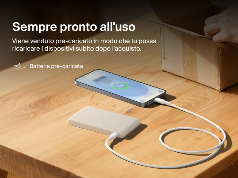 Belkin BoostCharge Slim Magnetic Power Bank 5K shown charging a smartphone on a table, highlighting its precharged battery ready for instant use out of the box.