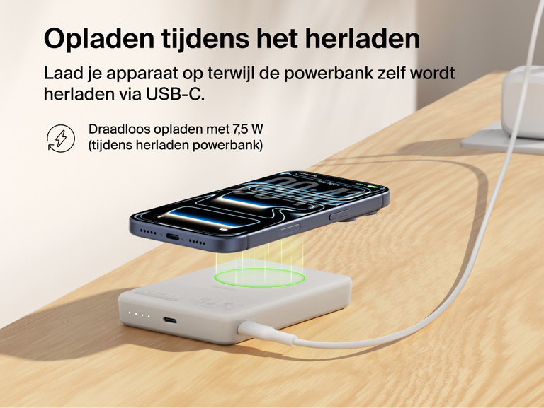 Belkin BoostCharge Slim Magnetic Power Bank 10K delivering pass-through charging with a smartphone wirelessly charging on top while the power bank recharges via USB-C cable
