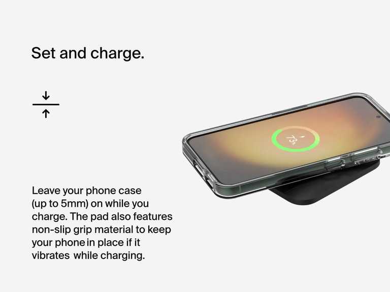 A smartphone with a clear protective case charges on the Belkin BoostCharge Universal Easy Align Wireless Charging Pad 15W, which supports cases up to 5mm thick and features a non-slip surface to keep devices securely in place.