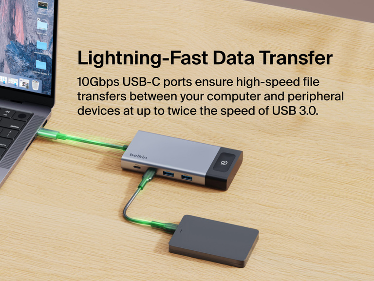 Belkin USB-C hub connected to a laptop and external drive on a desk, highlighting 10Gbps high-speed data transfer between devices.