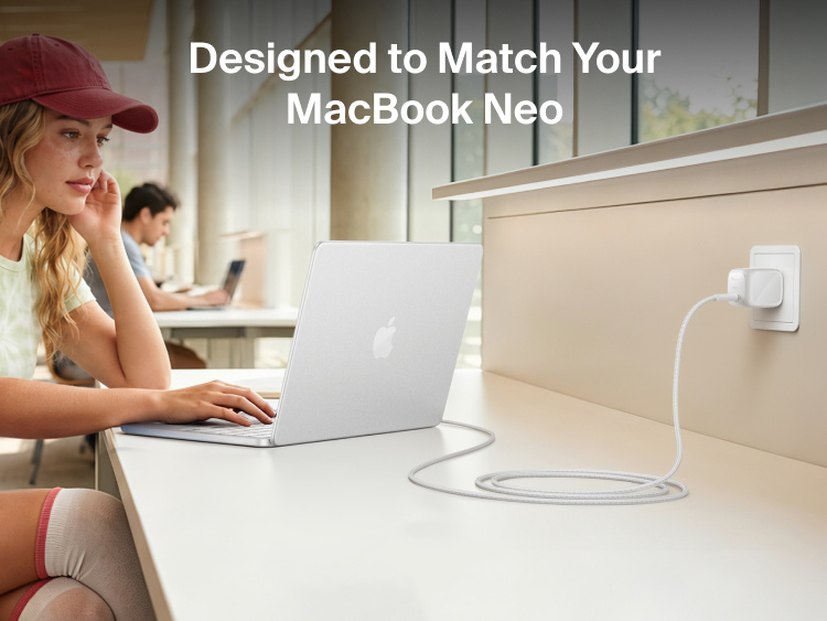 Person using a MacBook Neo connected to the Belkin BoostCharge Compact USB-C Charger 30W and braided USB-C cable at a study desk.
