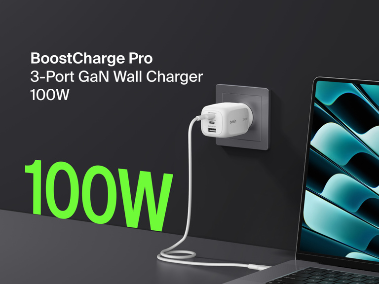 BoostCharge Pro 3-Port GaN Wall Charger 100W plugged into a wall outlet, fast charging a laptop with bold green “100W” text highlighting its powerful output.