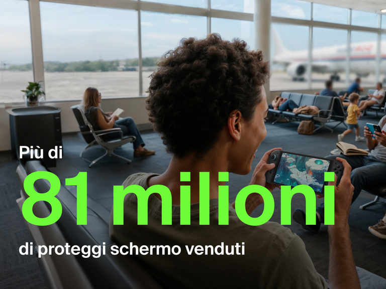 Una giovane persona sorride mentre gioca con un Nintendo Switch 2 in un gate all'aeroporto. Sullo sfondo, altri viaggiatori sono seduti e leggono o usano i loro telefoni, e un aereo è visibile attraverso le finestre. Il testo in verde a grandi caratteri legge "Più di 81 milioni", e il testo in bianco riporta "di proteggi schermo venduti", evidenziando la popolarità del prodotto.