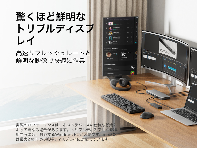 木製の机の上に、Thunderbolt 4ドックに接続されたノートパソコン、キーボード、モニターが配置されたホームオフィスのセットアップ。背景には収納棚や装飾品があります。