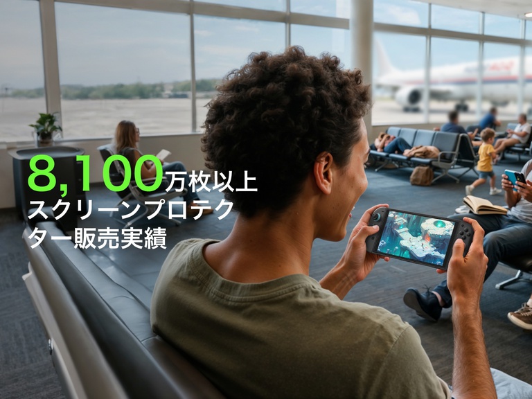 空港のゲートエリアで、若者がNintendo Switch 2でゲームをしながら笑顔を見せている。背景では、座って本を読んだり携帯電話を使ったりしている他の旅行者と、窓からは飛行機が見えます。前面の大きな緑色の文字には「81M+」と表示され、その下の白い文字には「画保護フィルムの販売数」が表示され、製品の人気が強調されています。