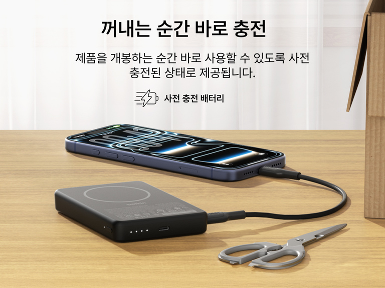 사전 충전하여 개봉 즉시 사용할 수 있는 Belkin BoostCharge 슬림 마그네틱 보조 배터리 10K를 책상 위에 두고 USB-C 케이블을 통해 스마트폰을 충전하는 모습