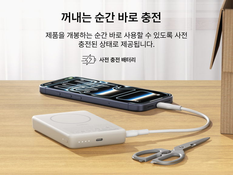 사전 충전하여 개봉 즉시 사용할 수 있는 Belkin BoostCharge 슬림 마그네틱 보조 배터리 10K를 책상 위에 두고 USB-C 케이블을 통해 스마트폰을 충전하는 모습