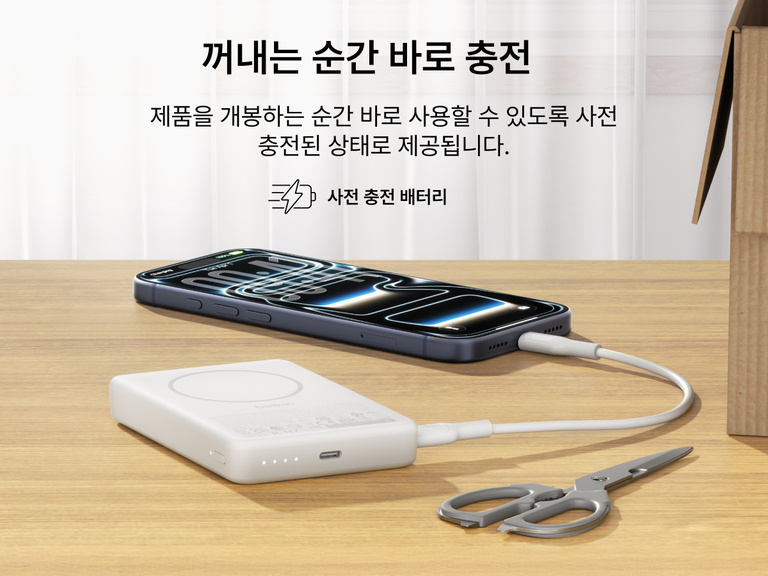 사전 충전하여 개봉 즉시 사용할 수 있는 Belkin BoostCharge 슬림 마그네틱 보조 배터리 10K를 책상 위에 두고 USB-C 케이블을 통해 스마트폰을 충전하는 모습