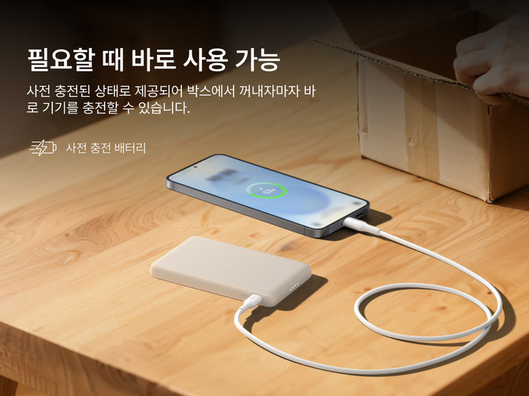 Belkin BoostCharge Slim Magnetic Power Bank 5K shown charging a smartphone on a table, highlighting its precharged battery ready for instant use out of the box.