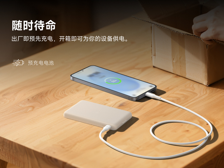 Belkin BoostCharge Slim Magnetic Power Bank 5K shown charging a smartphone on a table, highlighting its precharged battery ready for instant use out of the box.