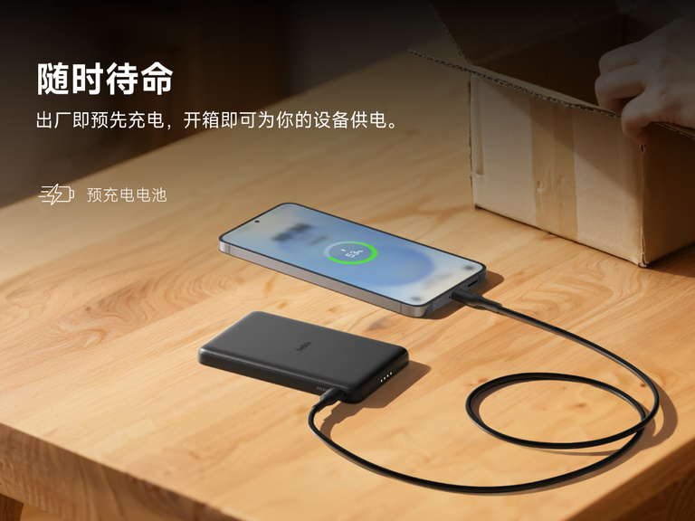 Belkin BoostCharge Slim Magnetic Power Bank 5K shown charging a smartphone on a table, highlighting its precharged battery ready for instant use out of the box.