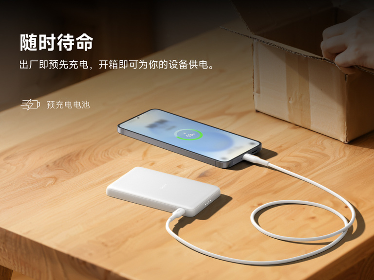 Belkin BoostCharge Slim Magnetic Power Bank 5K shown charging a smartphone on a table, highlighting its precharged battery ready for instant use out of the box.