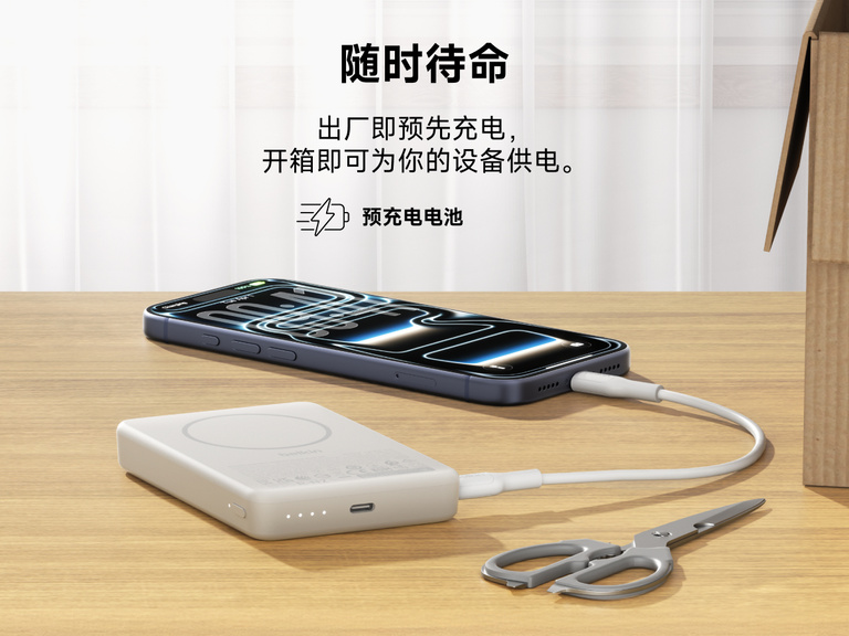 贝尔金 BoostCharge Slim 磁吸式移动电源 10K 开箱即带有预充电量，可通过 USB-C 线为智能手机充电，移动电源放置于桌面上