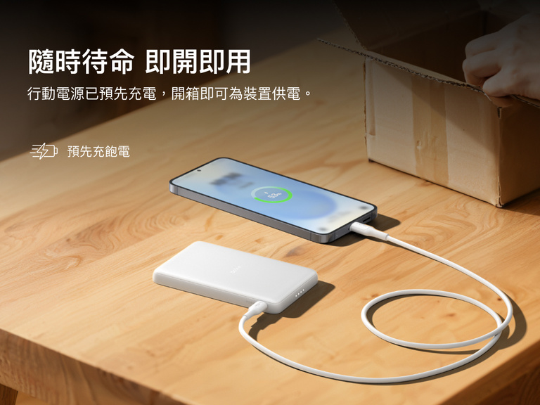Belkin BoostCharge Slim Magnetic Power Bank 5K shown charging a smartphone on a table, highlighting its precharged battery ready for instant use out of the box.