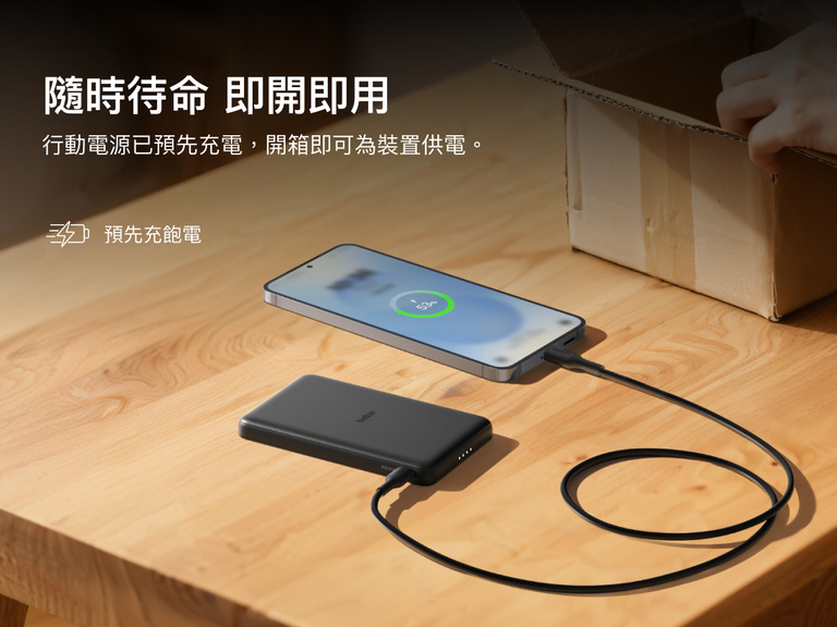 Belkin BoostCharge Slim Magnetic Power Bank 5K shown charging a smartphone on a table, highlighting its precharged battery ready for instant use out of the box.