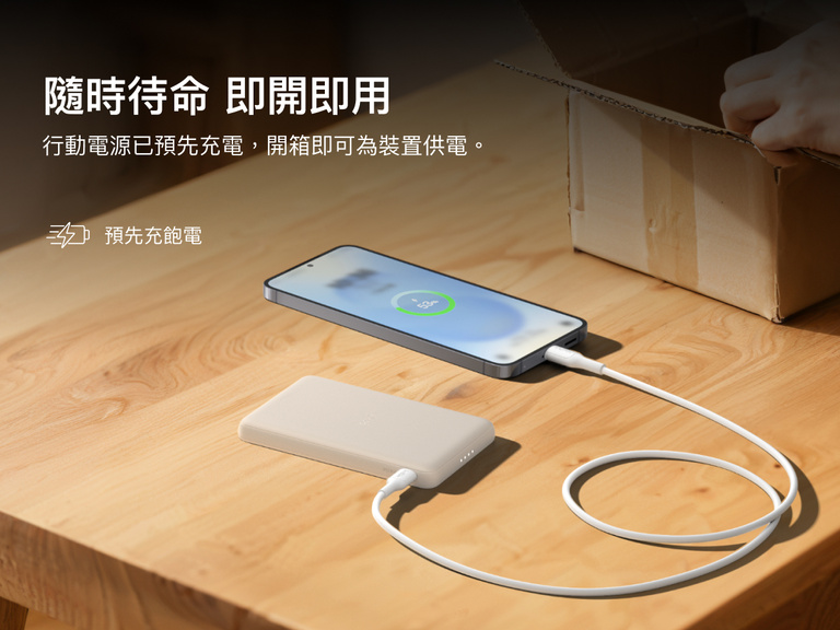 Belkin BoostCharge Slim Magnetic Power Bank 5K shown charging a smartphone on a table, highlighting its precharged battery ready for instant use out of the box.