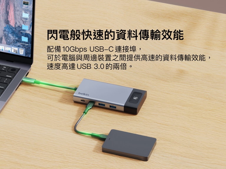 連接手提電腦和外部硬碟的 Belkin USB-C 集線器置於桌面上，突顯其裝置間 10Gbps 高速資料傳輸的能力。