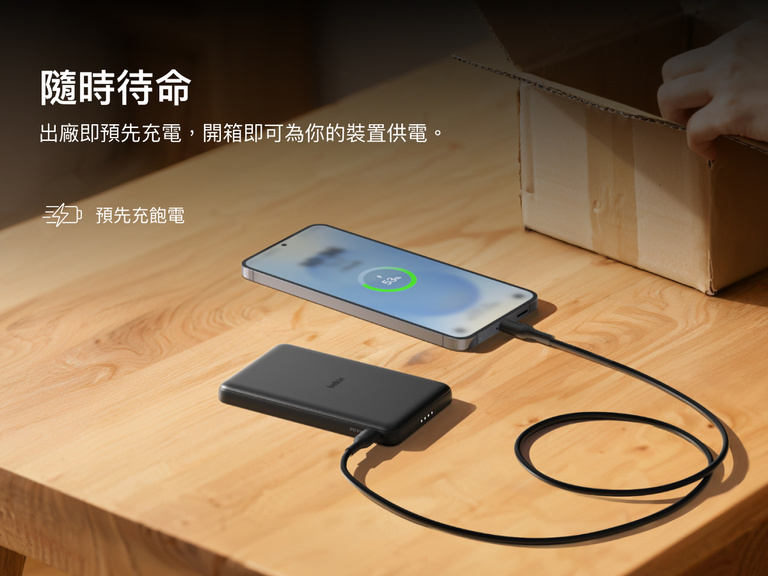 Belkin BoostCharge Slim Magnetic Power Bank 5K shown charging a smartphone on a table, highlighting its precharged battery ready for instant use out of the box.