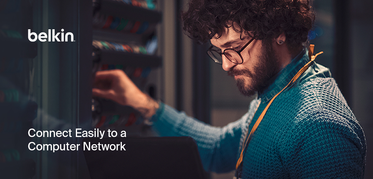 Alt text: 'A network technician with curly hair and glasses working in a server room, connecting cables to a network rack. The technician is wearing a blue sweater and an ID badge. The Belkin logo is displayed, with the text 'Connect Easily to a Computer Network' in the foreground, emphasizing ease of network setup and connectivity.'