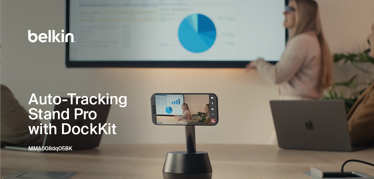 Belkin Auto-Tracking Stand Pro with DockKit capturing a presenter in action, with a smartphone on the stand recording a meeting while a pie chart is displayed on a large screen in the background.