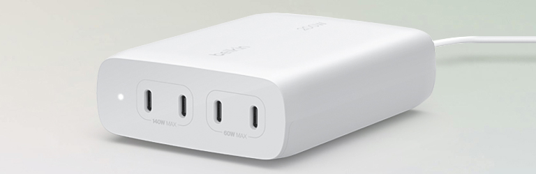 A white Belkin 200W USB-C GaN charger with four ports labeled for 140W and 60W output is shown connected on a soft gradient background.