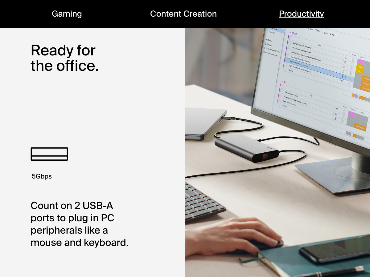 A person works at a desk using a monitor, keyboard, and mouse connected through the Belkin Connect Universal USB-C 8-in-1 Dual Display Core Hub, which supports two USB-A ports for 5Gbps connections.