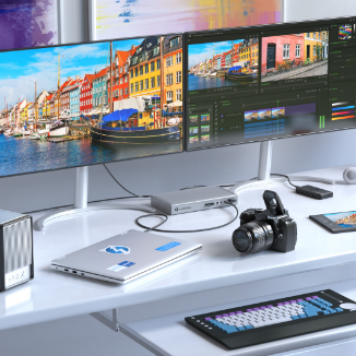 A modern workspace featuring dual monitors displaying a vibrant European harbor scene and video editing software. The clean white desk is equipped with a laptop, an external GPU enclosure, a professional camera, a mechanical keyboard, and a docking station. Additional accessories include a tablet, a wireless mouse, and neatly arranged office items, creating an efficient and stylish workstation for creative professionals.