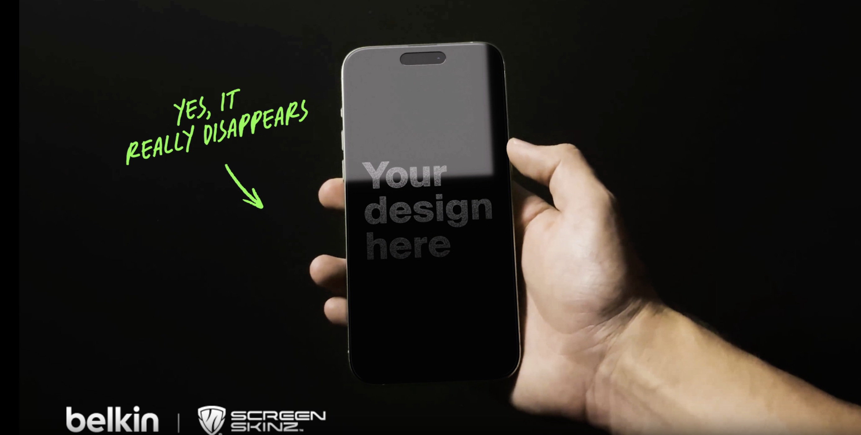 Hand holding a smartphone with a customizable privacy screen protector displaying &ldquo;Your design here,&rdquo; with text indicating the design disappears from side angles, alongside Belkin and Screen Skins branding.