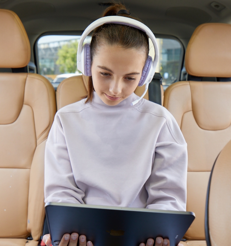 An image of a child using a tablet connected to a Belkin Wireless Over-Ear Headset for Kids.