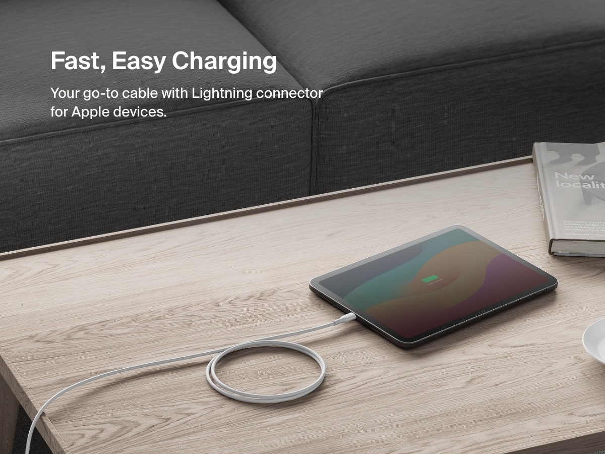 圖中顯示的 Belkin BoostChargeUSB-C 至 Lightning 連接線正在為咖啡桌上的 iPad 充電，強調能輕鬆快速為 Apple 裝置充電。