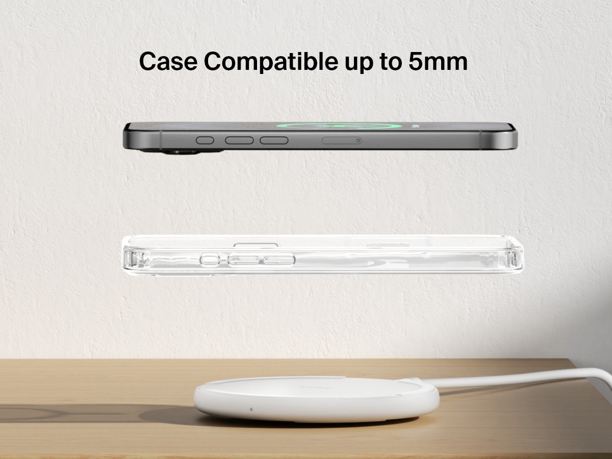A white Belkin BoostCharge Wireless Charging Pad 15W is shown on a wooden surface with an iPhone and a transparent case floating above it, highlighting its compatibility with cases up to 5mm thick.