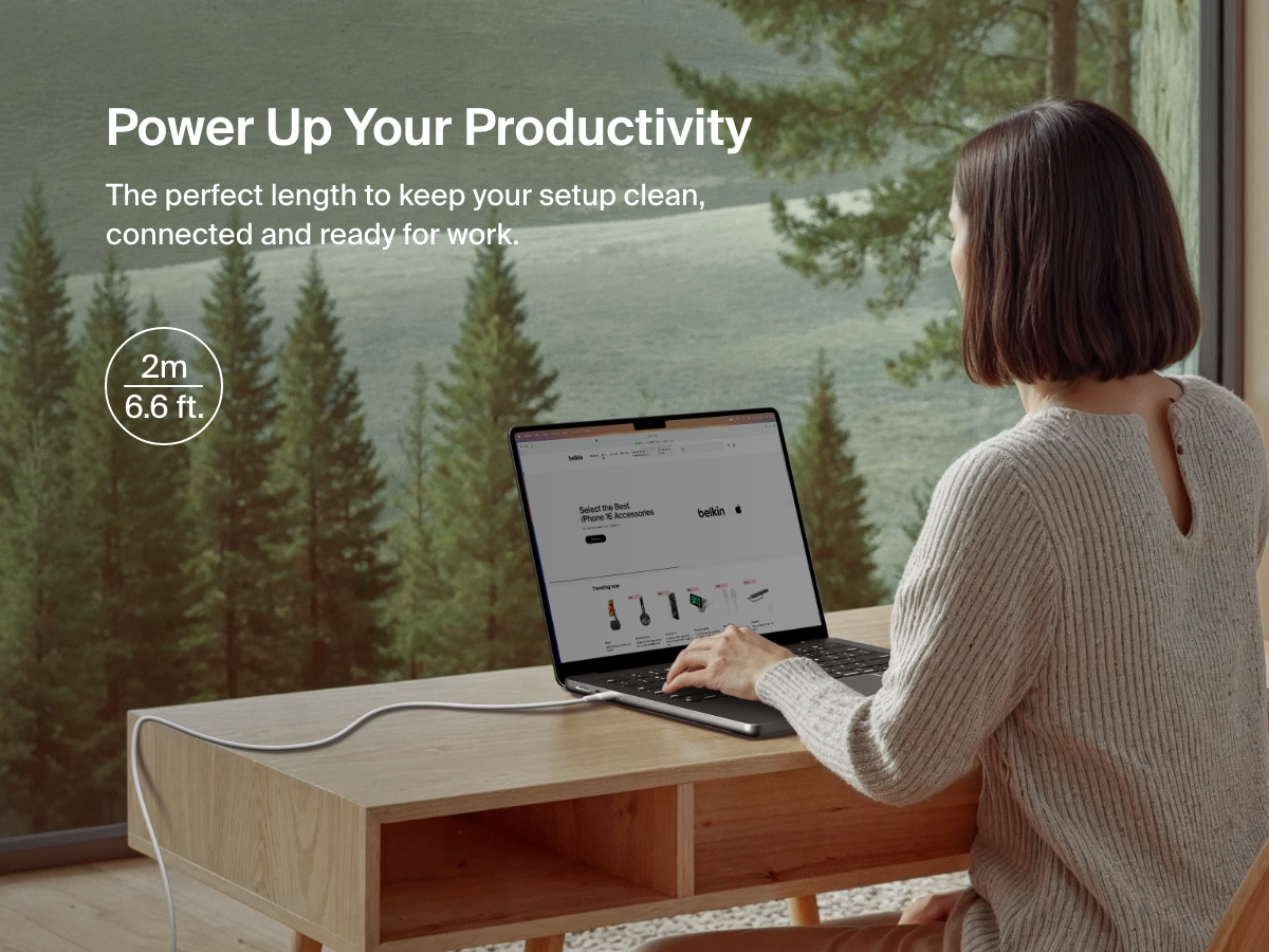 Belkin BoostCharge Pro USB-C to USB-C 브레이디드 케이블 60W에 노트북을 연결하여 사용하는 여성. 2m 길이로 깔끔하고 유연한 홈 오피스 환경을 구축하는 데 적합합니다.