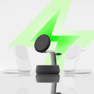 Three modern Belkin wireless charging stands displayed on a reflective surface, with a large green lightning bolt in the background symbolizing fast charging; two white stands on the sides and a black stand in the center.