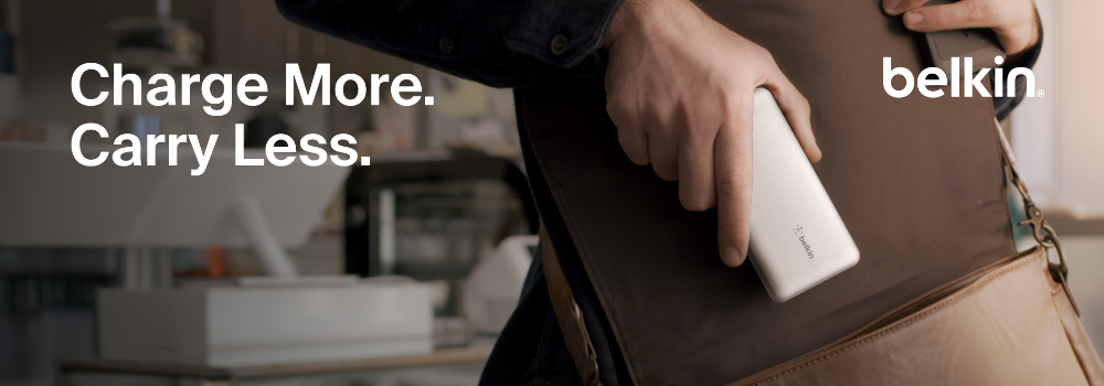 A person sliding a compact Belkin portable power bank into a brown shoulder bag, with the text “Charge More. Carry Less.” displayed on the left side.