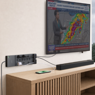 Belkin 12-Outlet Home/Office Surge Protector with an 8-foot cord mounted on a wall, powering a TV, soundbar, and smartphone in a modern living room.