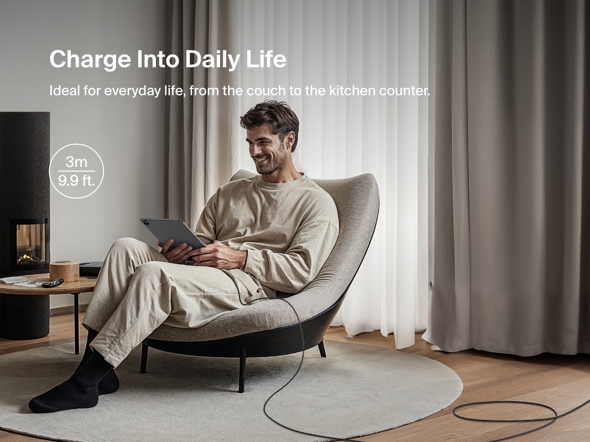A man relaxes in a chair using a tablet connected to a 3-meter (9.9 ft) Belkin BoostCharge Pro Braided USB-A to USB-C Cable 15W, ideal for convenient everyday charging from a distance.