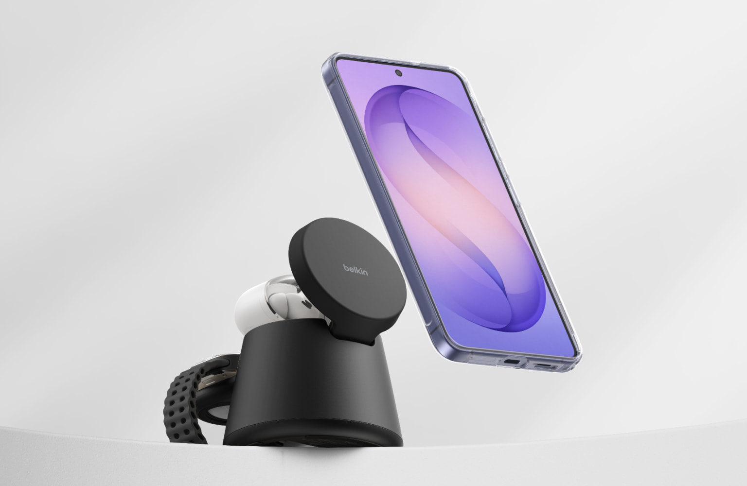 Smartphone hovering above a Belkin magnetic wireless charging stand, illustrating hands-free charging and magnetic alignment.